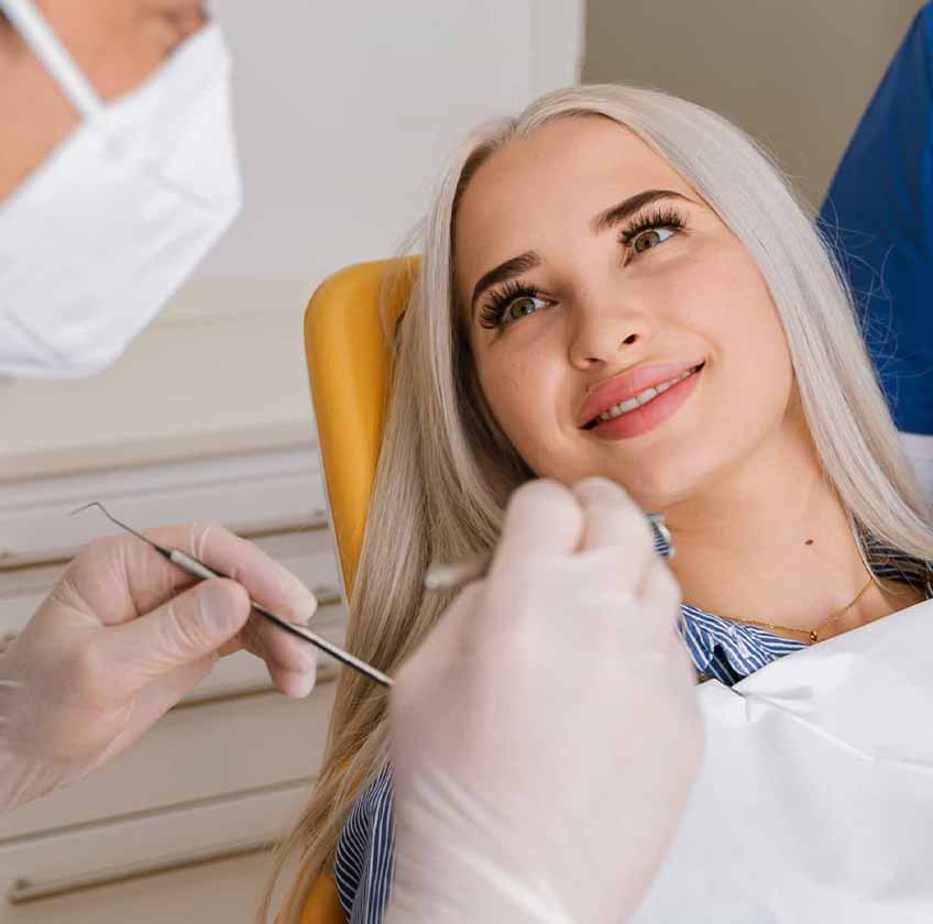 Zahnarzt bei der Vorsorgeuntersuchung einer Patientin. 